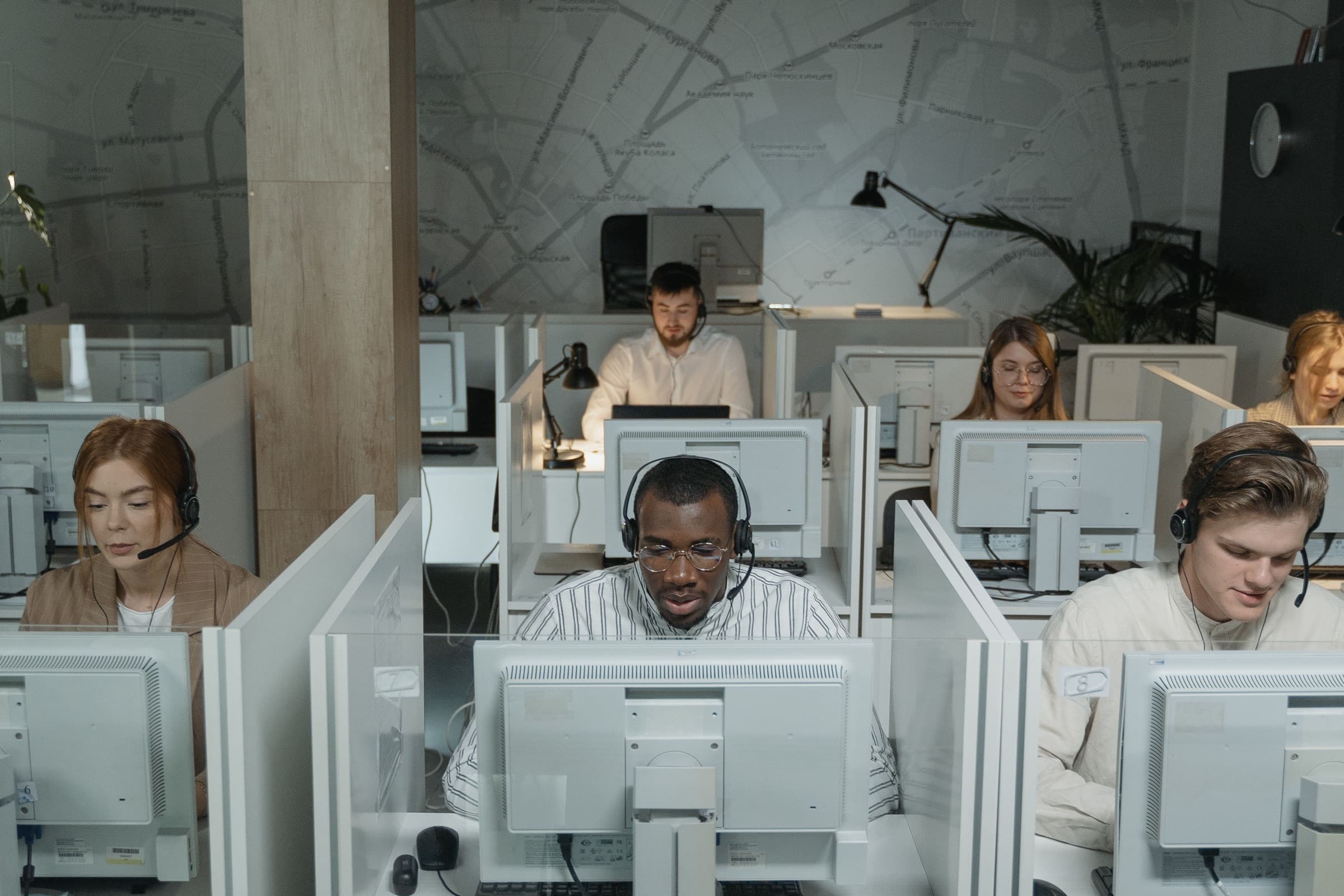 Medewerkers met headsets nemen gesprekken aan in een callcenter